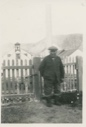 Image of Eskimo [Inuk] man standing near church